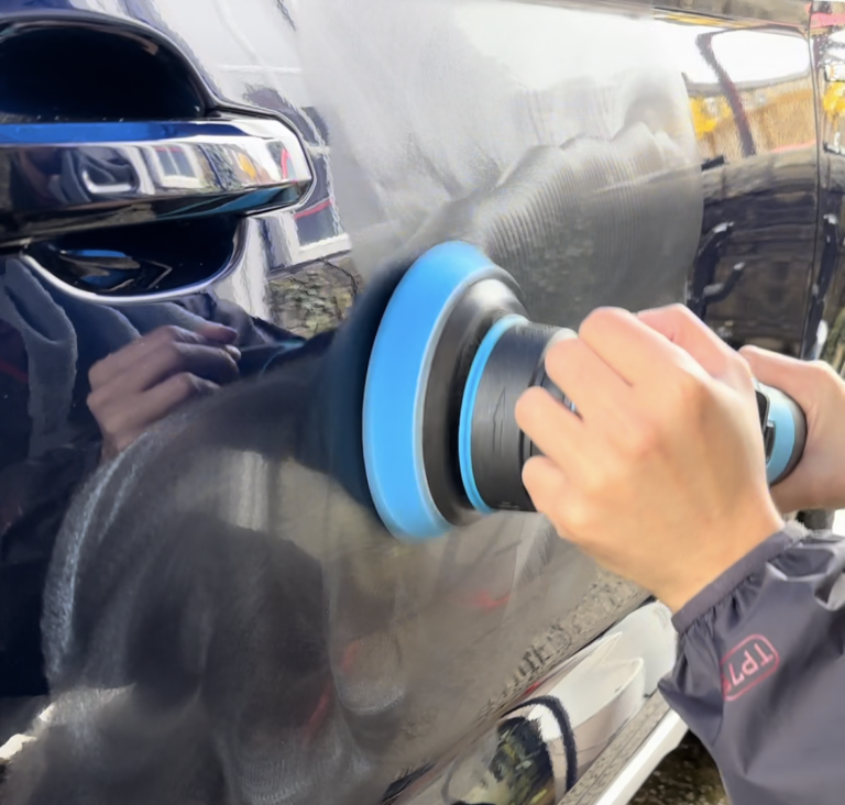 Polishing a blue car, with a dual action polisher.