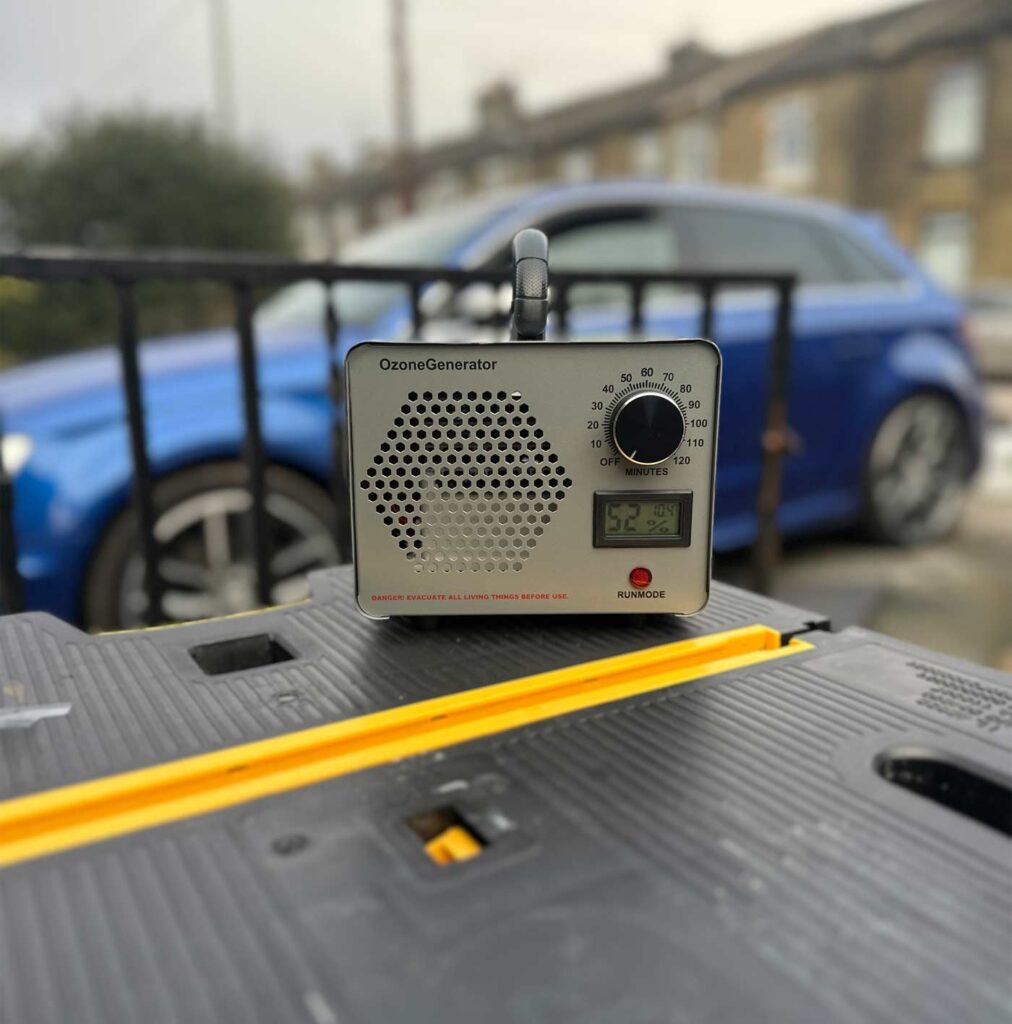 An ozone treatment machine operating outdoors with a sleek Audi S3 in the background, showcasing an advanced odour and sanitisation service as part of professional car detailing.