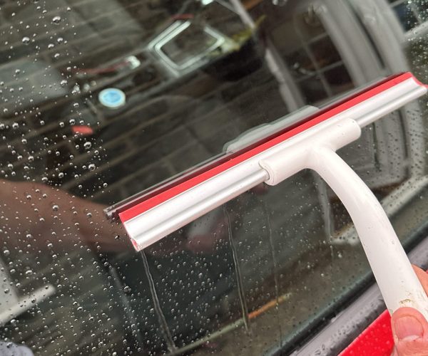 Car window being cleaned using a window cleaning device