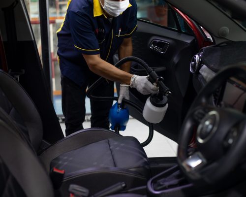 Man performing full valet with steam cleaner